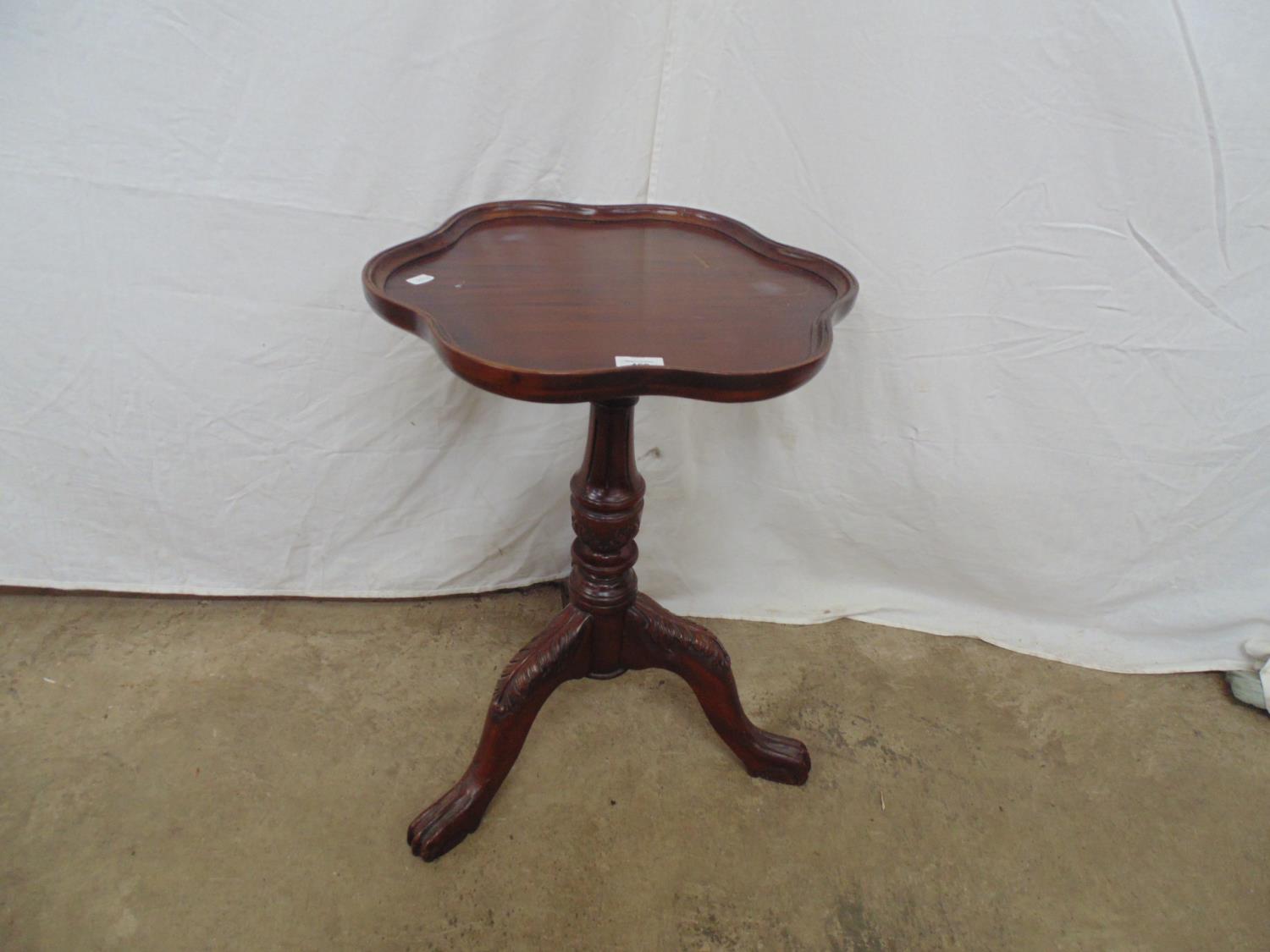 Reproduction mahogany occasional table the shaped top over baluster column leading to three cabriole