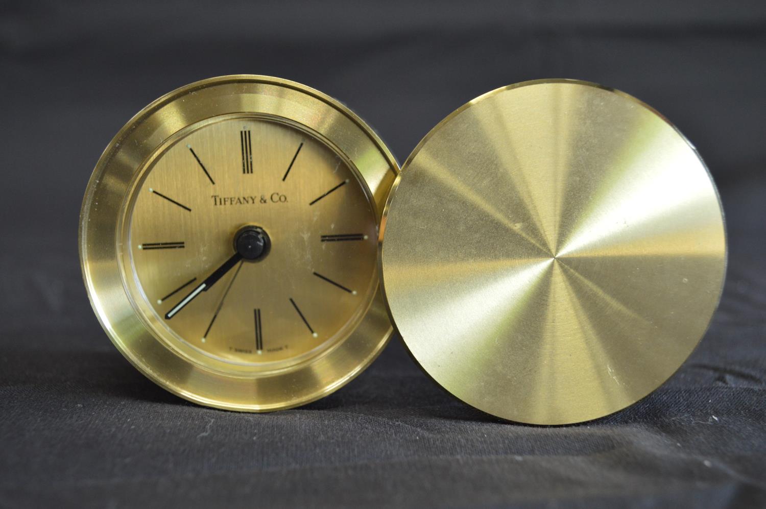 Tiffany & Co. brass cased travel alarm clock with rotating cover - 6cm dia Please note