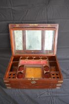 Brass bound and inlaid mahogany vanity travelling box opening to reveal fitted interior and mirror