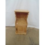 Pine bedside/pot cupboard having open recess with shaped sides over a single cupboard door, standing