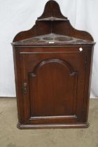 Georgian oak wall hanging corner cupboard having shaped raised back with single shelf over