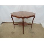 Mahogany two tier occasional table the shaped top over shaped frieze and carved shoulders leading to