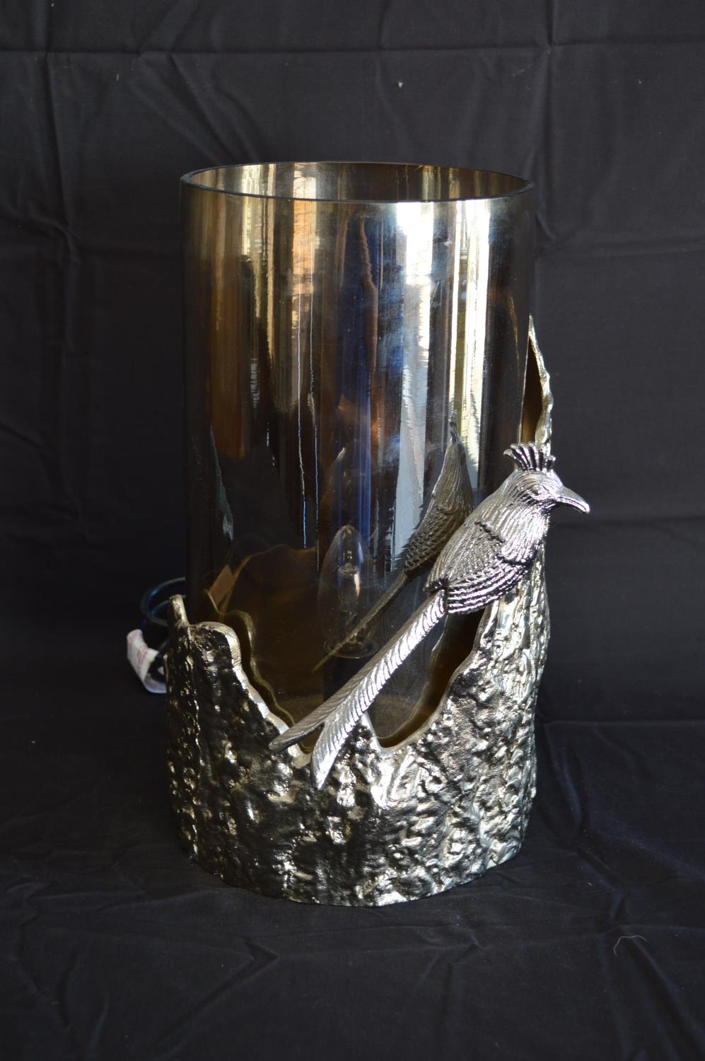 Cylindrical metal table lamp in the form of a section of tree trunk and bird with smoked glass shade