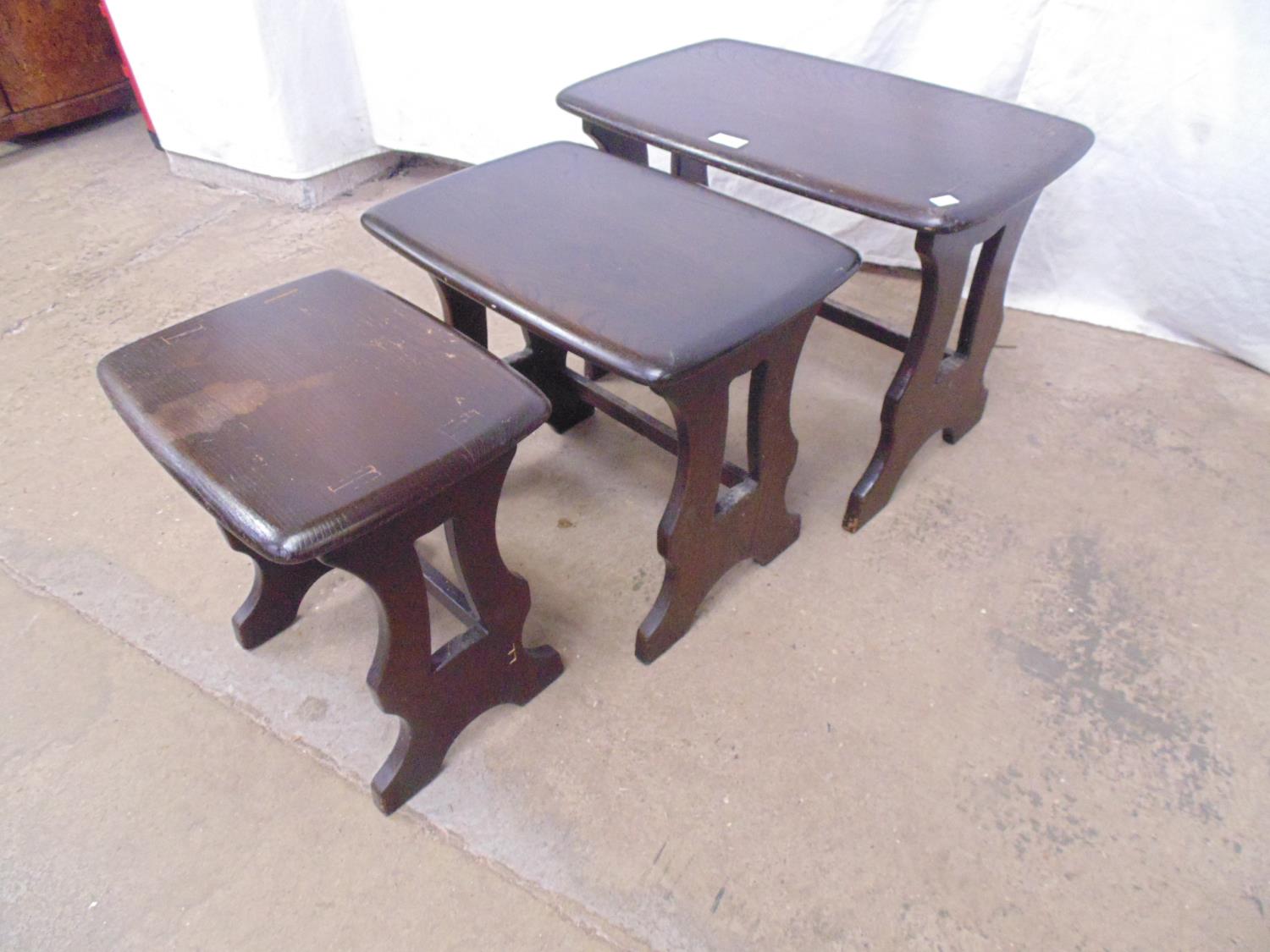 Nest of three dark Ercol style elm tables standing on pierced shaped legs - largest 58cm x 36cm x - Image 4 of 4