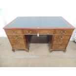 Mahogany twin pedestal desk having green leather insert to top over central drawer blanked by