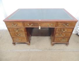 Mahogany twin pedestal desk having green leather insert to top over central drawer blanked by