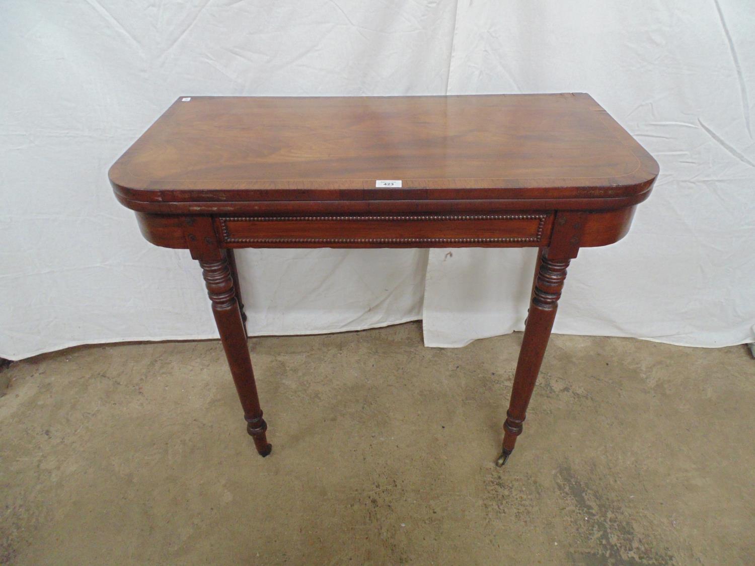 Inlaid mahogany card table having green baized playing surface over four turned legs ending in