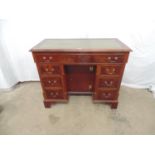 Mahogany dog kennel desk having gilt tooled leather insert to top over an arrangement of one long