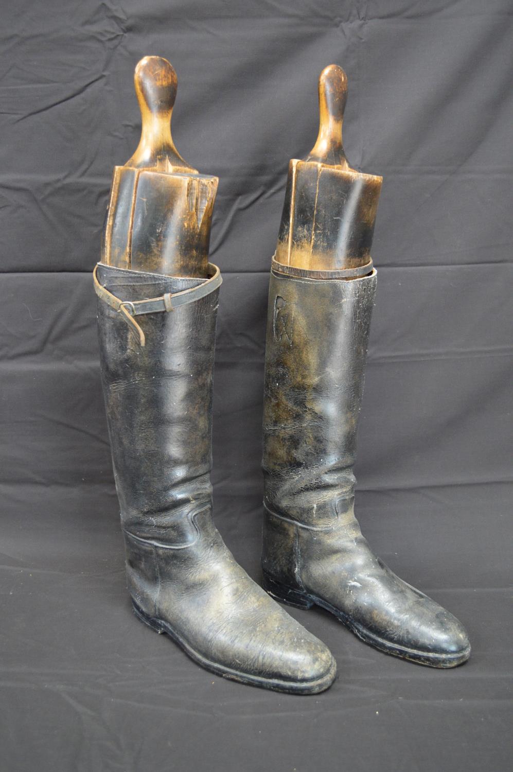 Pair of black leather riding boots with wooden trees Please note descriptions are not condition