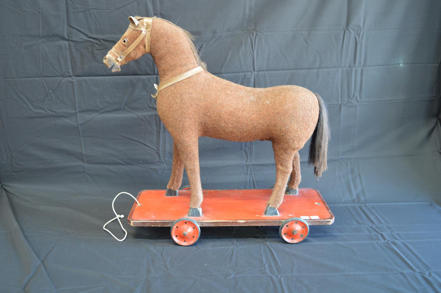 Vintage childs pull-a-long horse with wooden hoofs and mouth, standing on painted wooden base with