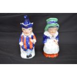 Pair of Staffordshire Toby jugs in the form of Punch and Judy complete with hat formed lids - 28cm