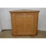 Pine floor standing corner cupboard having moulded cornice over single door, standing on plinth base