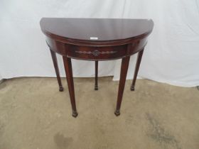 Mahogany demi lune card table having hinged top with green baize and standing on square tapering