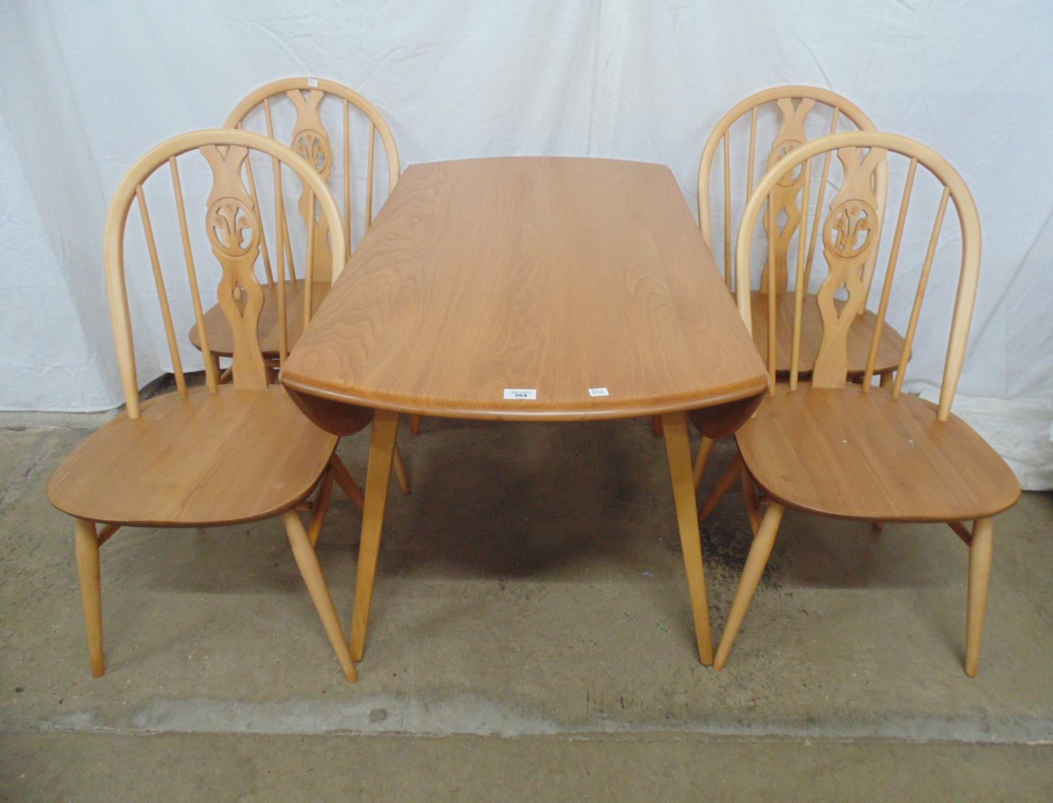 Set of four blonde Ercol hoop back chairs having fleur de lis back splat, standing on round tapering