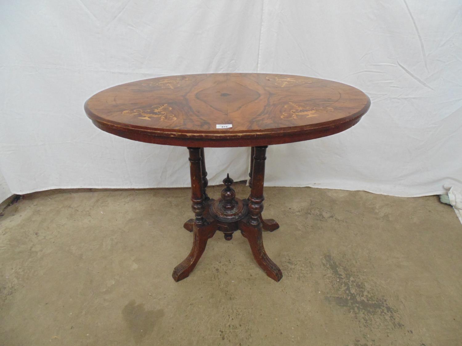 Inlaid walnut loo table having oval top standing on tour turned legs leading to central finial and