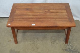 Teak coffee table with slatted top on stretchered moulded legs, bearing label for The Hughes Bolckow