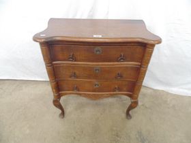 Small oak chest of drawers having a shaped top over three drawers, standing on cabriole legs -
