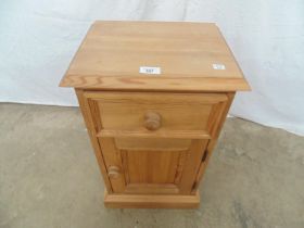 Modern pine bedside cupboard having a single drawer over cupboard base, standing on a plinth