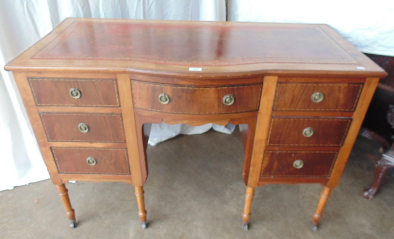 Mahogany inlaid bow fronted kneehole writing desk having red leather insert with gilt tooling over