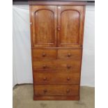 Victorian mahogany cupboard on chest the arched panelled doors opening to a single fixed shelf