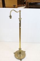 Late 19th / Early 20th century Brass Standard Reading Lamp, the circular base with three scroll feet