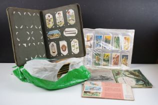 A small collection of cigarette and tea collectors cards to include albums and loose examples.