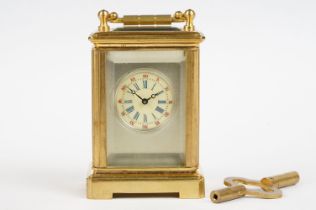 A miniature antique brass cased carriage clock with enamel panels with cherub decoration.
