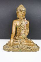 Carved wooden figure of a Thai seated Buddha, with serene facial expression, sequinned & gilt