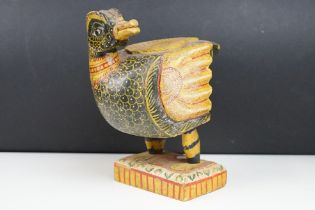 South East Asian carved wooden duck sculpture with painted decoration, raised on a rectangular base.