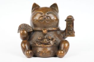 An ornamental Japanese bronze 招き猫 / maneki-neko (waving / beckoning) lucky cat talisman.