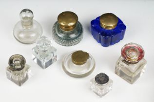 A collection of eight vintage glass inkwells to include a blue glass example.