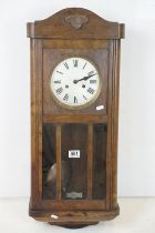 Early 20th Century oak cased pendulum wall clock having a round dial with roman numeral chapter