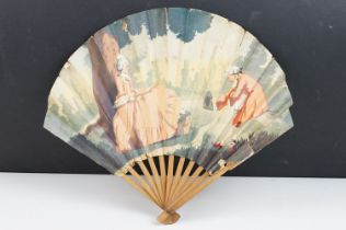 An antique French paper fan with figural decoration on wooden frame, marked the Ritz Restaurant to