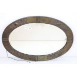 Arts and Crafts Copper Framed Oval Mirror with relief decoration and bevelled edge, 87cm x 60cm