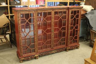Red Lacquered and Gilt decorated Inverted Breakfront Display Cabinet in the Chinese manner, the