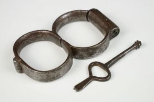 Pair of 19th century steel handcuffs, approx 13cm wide, with key