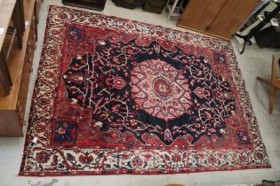 Large Wool Red and Blue Ground Rug with stylised pattern within a border, 308cm x 220cm