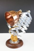 Retro style concertina adjustable table lamp, with coppered shade, raised on a circular wooden base