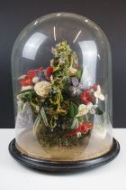 19th Century Victorian glass dome having a round ebonised wooden base housing a woollen floral