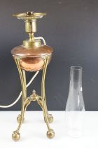 W.A.S. Benson Arts & Craft oil lamp, with a copper font over a brass tri-form base with paw & ball