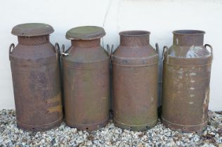 Collection of four steel milk churns of typical form, two with lids. Measure approx 75cm tall