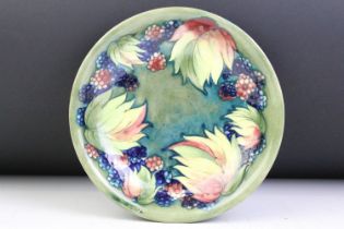 William Moorcroft 'Leaf and Berry' pattern green ground circular dish, signed to reverse,