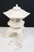 White ceramic table lamp modelled as a pagoda, with lustre finish, raised on four legs, measures