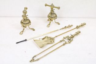 An antique brass fireside companion set to include tongs, shovel and poker together with two piece