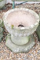 Large reconstituted stone planter with gadrooned decoration, raised on an octagonal stone base (