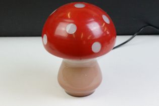 Glass toadstool mushroom lamp having a pink glass base with red painted shade. Measures approx