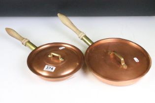 Two copper cooking pans, with covers & turned wooden handles. Largest approx 48cm long (including