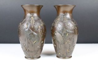 Pair of Japanese bronze baluster vases, the relief crane & foliate decoration with gold coloured