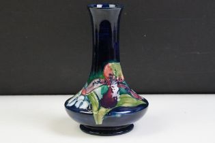 Moorcroft Orchid pattern vase having a blue ground with tube lined floral detailing. Impressed marks