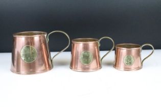 Set of Three Antique Copper Ale Measuring Tankards or Mugs, each set with a brass roundel